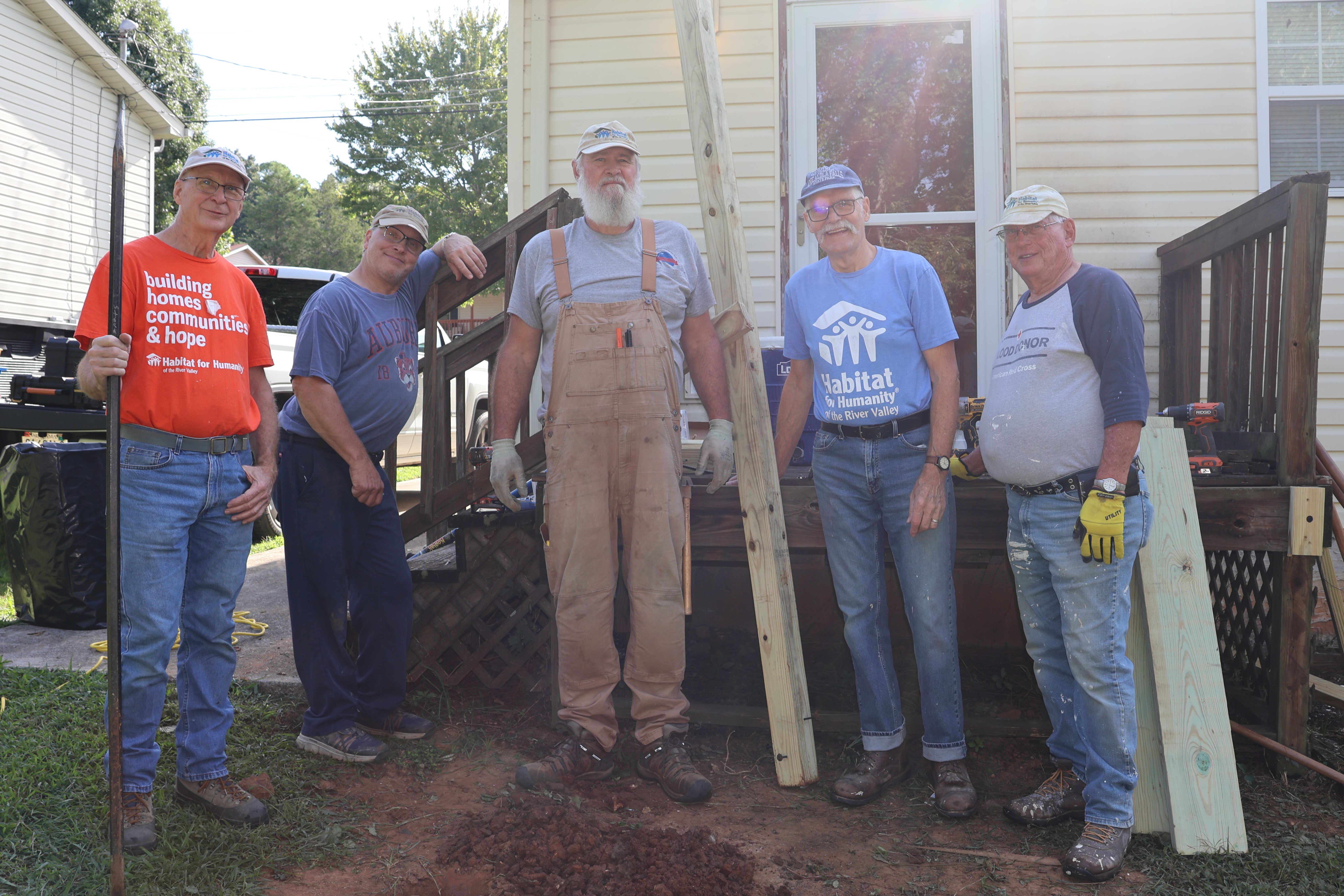 Habitat volunteers standing in front of a home after completing porch repairs