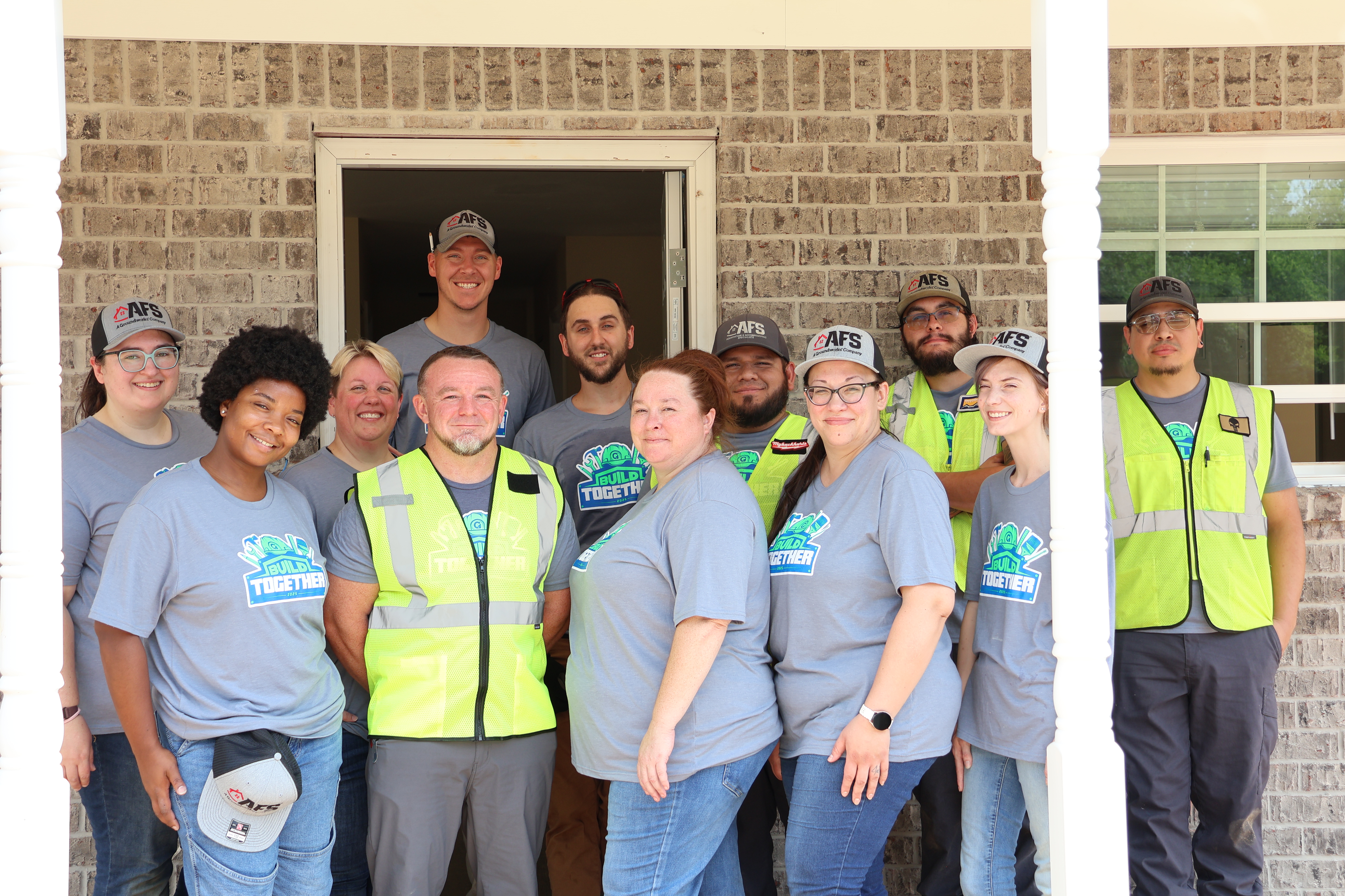 Corporate team in safety vests volunteering with Habitat