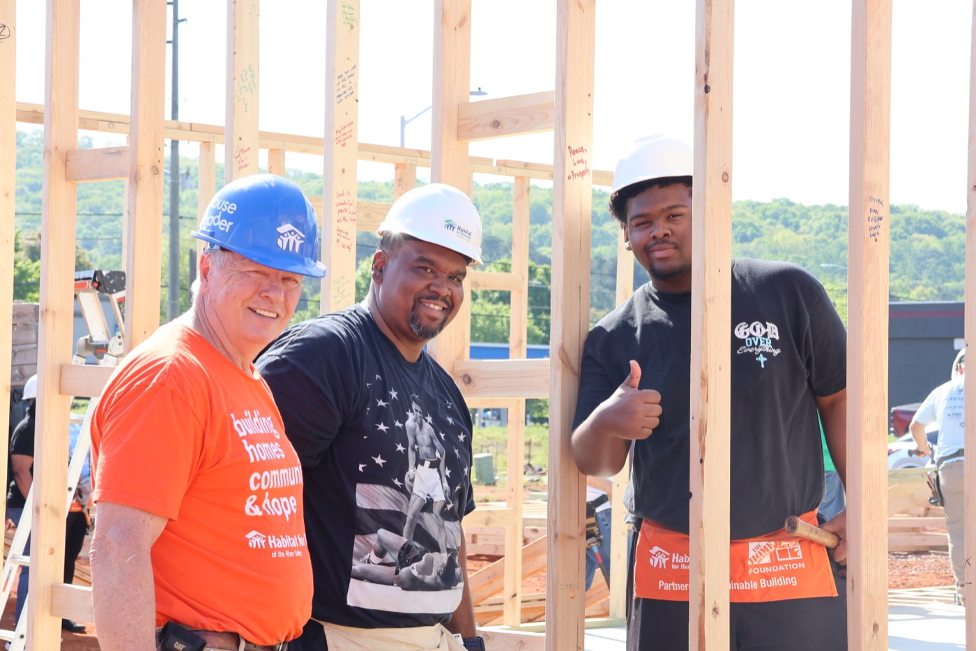 A group of volunteers framing a wall together on a Habitat build site